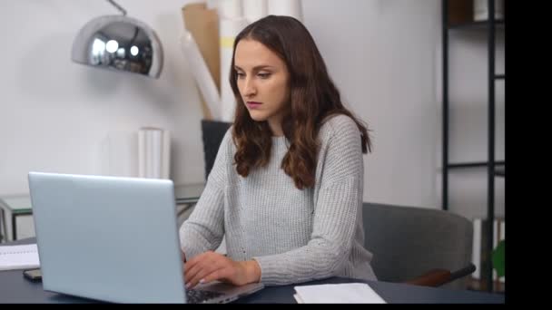 Mulher jovem cansado se sente cansado sentado na frente de um laptop no escritório moderno — Vídeo de Stock