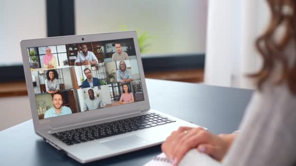 Jovem mulher usando um laptop para conexão de vídeo com grupo diversificado de pessoas — Vídeo de Stock