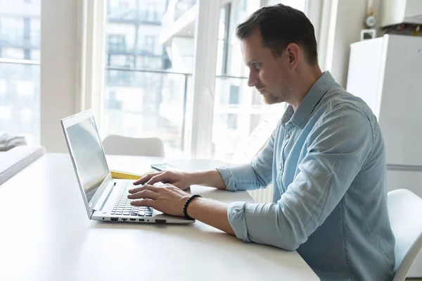 Sidovy på koncentrerad ung affärsman skriva på tangentbordet — Stockfoto