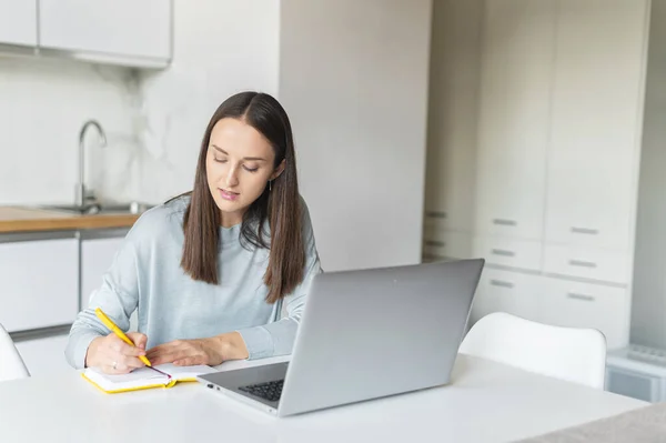 Urocza młoda kobieta korzystająca z laptopa do pracy w domu — Zdjęcie stockowe
