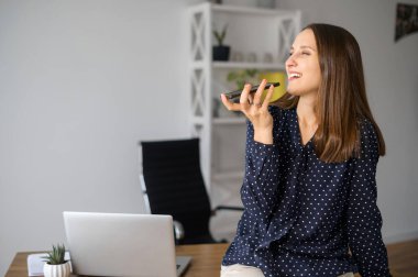 Genç kadın ofiste sesli mesaj kaydediyor.