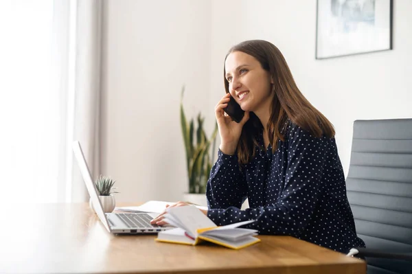 Female office employee takes a phone call