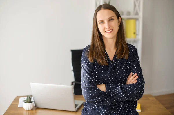 Frau steht mit verschränkten Armen drinnen — Stockfoto