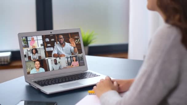 Jovem mulher usando um laptop para conexão de vídeo com grupo diversificado de pessoas — Vídeo de Stock