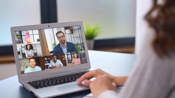 Jovem mulher usando um laptop para conexão de vídeo com grupo diversificado de pessoas — Vídeo de Stock