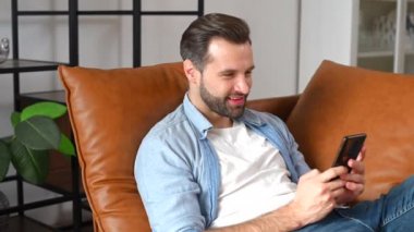 Evde cep telefonu kullanan yakışıklı bir genç.