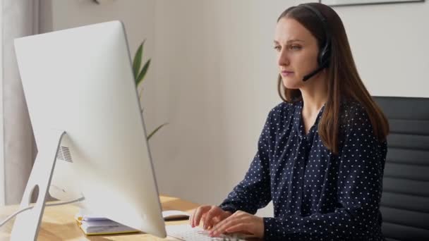 Woman is using headset for online communication — Stock Video