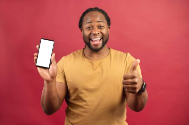 Akıllı telefonlu neşeli Afro-Amerikalı adam kırmızıda izole edilmiş.