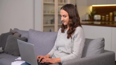 Evden uzak bir iş için dizüstü bilgisayar kullanan konsantre bağımsız bir kadın.
