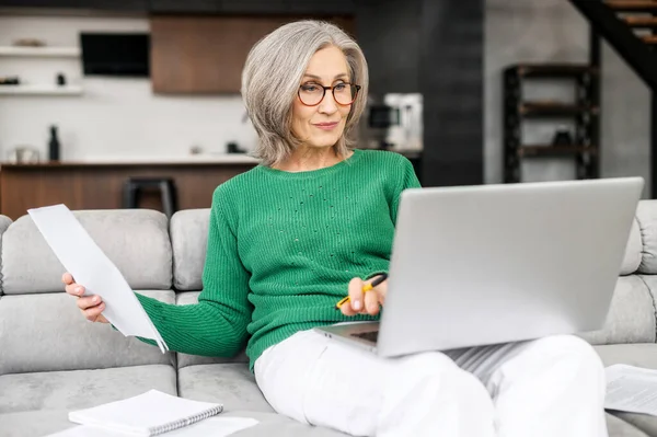 Vacker äldre kvinna som använder laptop hemma — Stockfoto