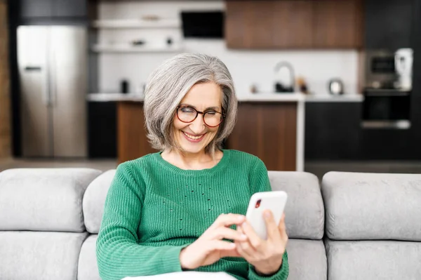 Beautiful senior woman using smartphone at home — Stock Photo, Image