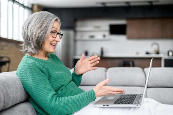 Piękna seniorka korzystająca z laptopa w domu — Zdjęcie stockowe