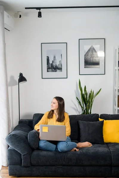 O femeie tânără cu un laptop acasă — Fotografie, imagine de stoc