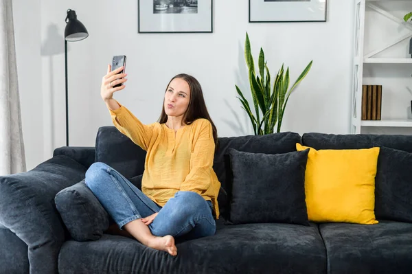 Chica joven con un teléfono inteligente, habla en línea — Foto de Stock