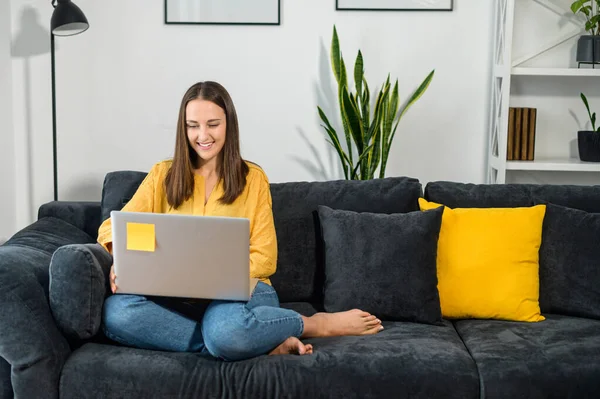 Een jonge vrouw met een laptop thuis — Stockfoto