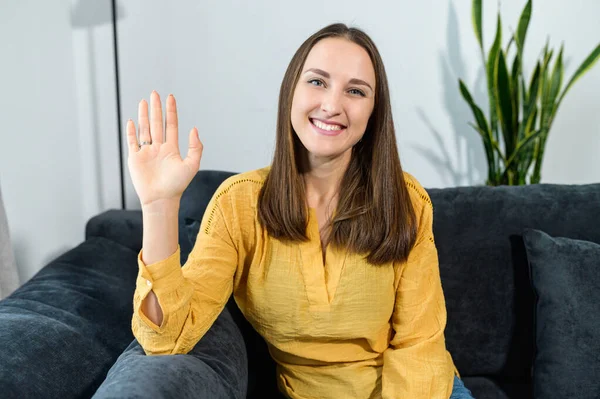 A young woman sits at the couch at home — Stock Photo, Image