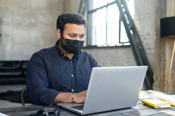 Portrait of indian man in protective facial mask in the workplace