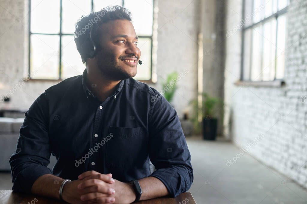 Indian guy using headset in modern office