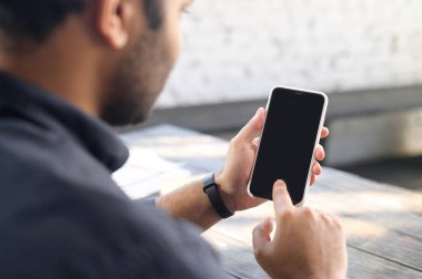 Arka plan melez adam boş ekranlı akıllı telefon aygıtı kullanıyor.