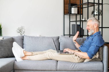 Taraf görünümü: Yetişkin sakallı adam akıllı telefondan video bağlantısı üzerinden konuşuyor.