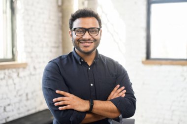 Şık gömlekli hırslı Hindu adam kolları bağlı duruyor.