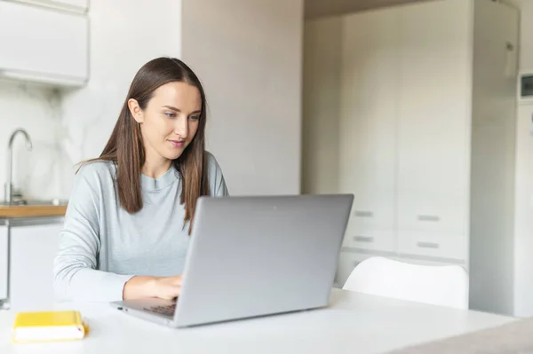 젊은 여성 이 노트북 컴퓨터를 사용하여 집에서 일하는 모습, — 스톡 사진