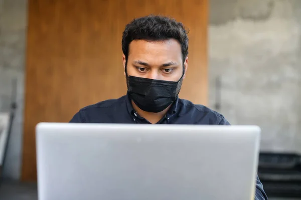 Портрет стурбованого індіанця в захисній масці на робочому місці. — стокове фото