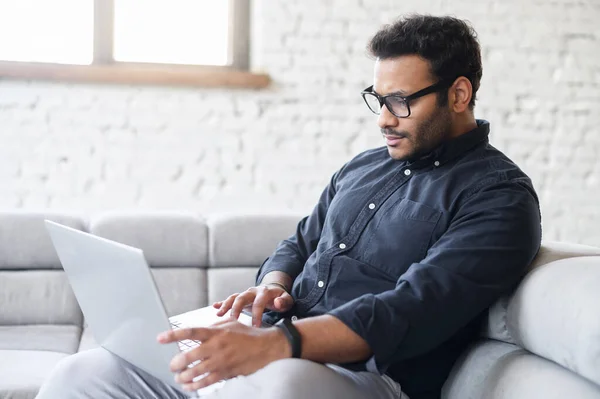 Allvarlig multiracial man med bärbar dator för fjärrarbete hemifrån — Stockfoto
