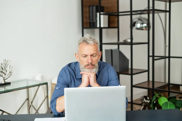 L'uomo d'affari anziano contemporaneo di capelli grigi si siede davanti al computer portatile — Foto Stock