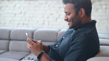 Çok ırklı Hintli serbest çalışan adam akıllı telefon kullanıyor.