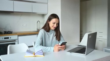 Kızın elinde akıllı bir telefon var ve internette sohbet ediyor.