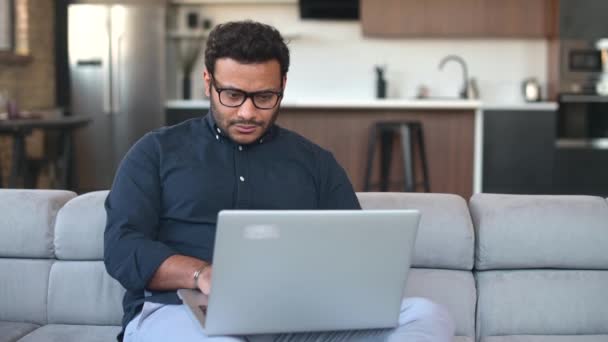 Multi-étnico hindú freelancer chico usando ordenador portátil en casa — Vídeos de Stock