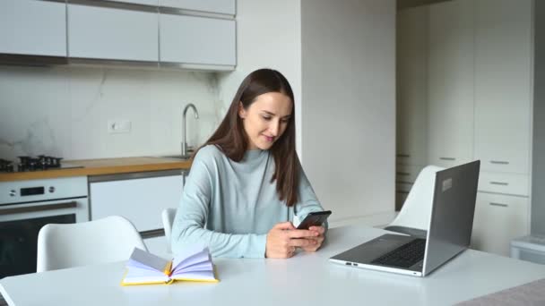 Mädchen hält Smartphone in der Hand und chattet online — Stockvideo