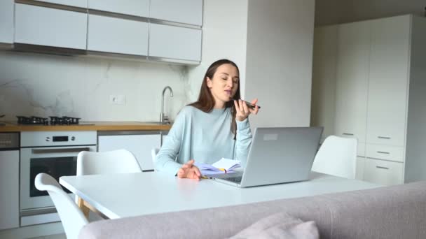 Young woman is sending audio voice message by her smartphone