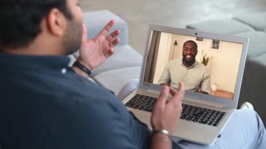 Hintli adam Afrikalı-Amerikalı erkek meslektaşıyla video bağlantısı için bilgisayar uygulaması kullanıyor.