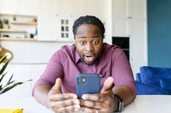Fantastisk svart kille överraskad med oväntade goda nyheter sitter i modern lägenhet — Stockfoto