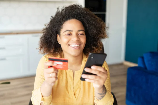 Młoda Afroamerykanka używa smartfona do zakupów online — Zdjęcie stockowe