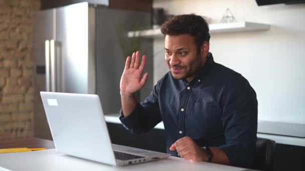 Video meeting concept. Cheerful hindu guy using laptop for video connection — Stock Video