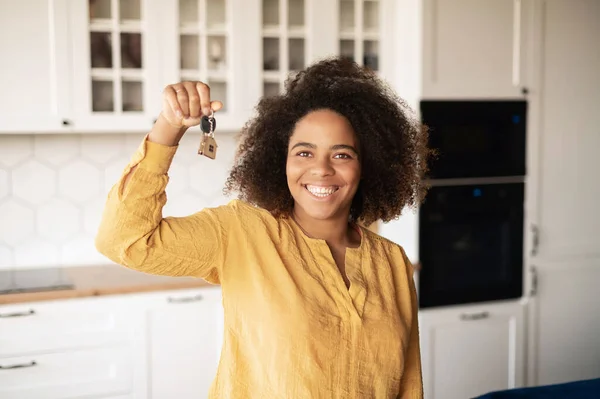 Happy excited African-American woman holding keys