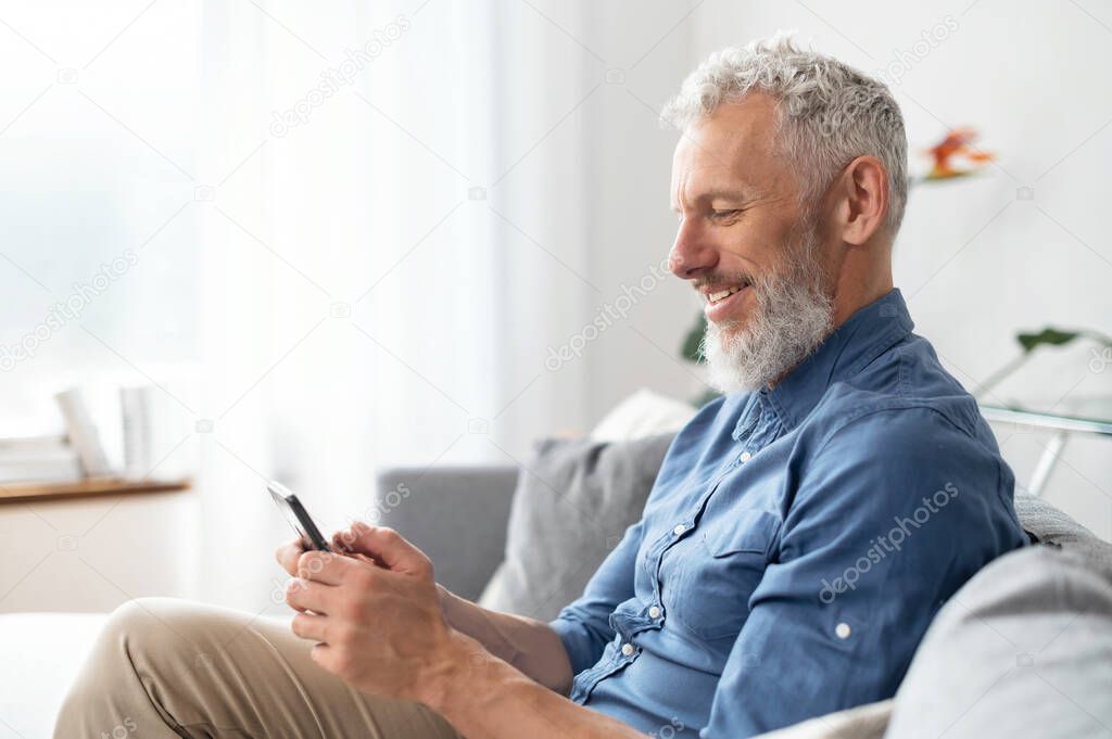 Middle aged bearded man using smartphone