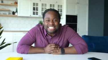 Afro-Amerikan online öğretmen kameraya bakar ve uzaktan konuşur.