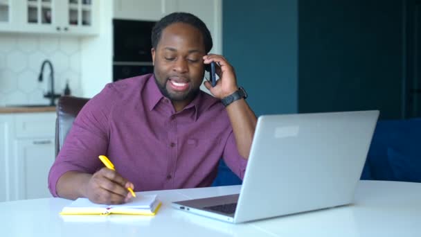 Multitarea y ocupado empresario afroamericano masculino utilizando ordenador portátil — Vídeo de stock