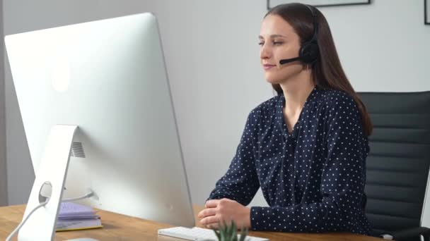 Mulher está usando fone de ouvido para comunicação online — Vídeo de Stock