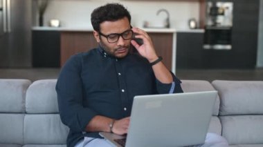 Evde dizüstü bilgisayar kullanan çok ırklı Hintli bir serbest çalışan.