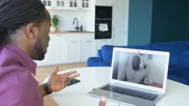 Sanal toplantı için dizüstü bilgisayar kullanan Afro-Amerikalı bir adam.