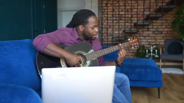 Афроамериканец, играющий на акустической гитаре, потоковое видео и выступающий онлайн — стоковое видео