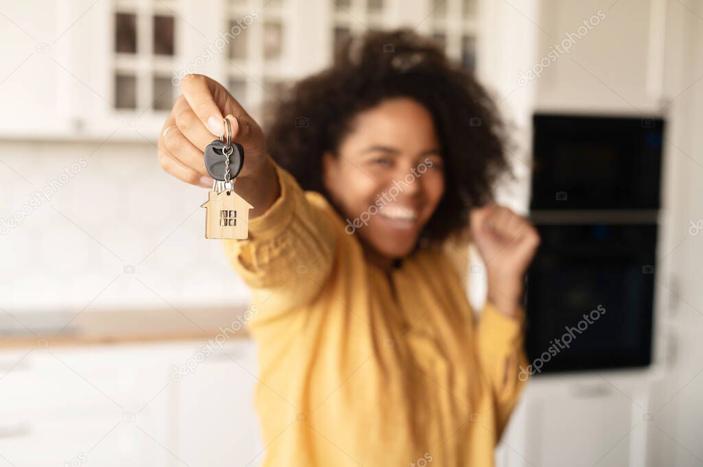 Happy excited African-American woman holding keys
