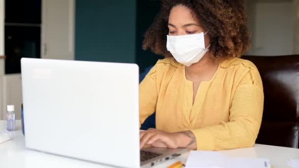 African-American young woman using laptop wearing protective mask — Stock Video