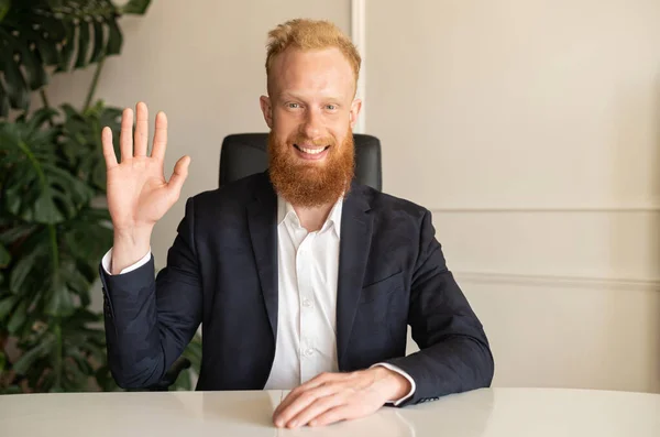 Smiling businessman in smart casual suit looks at the camera and waving, — Stock Photo, Image