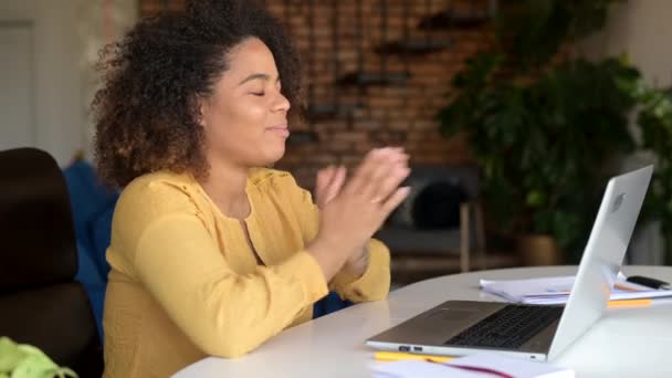 Glad lockigt afroamerikansk ung kvinna talar online, med bärbar dator — Stockvideo